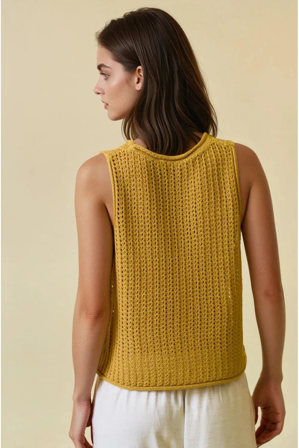 A mustard-yellow sleeveless open stitch sweater round neck tank top with a textured ribbed pattern