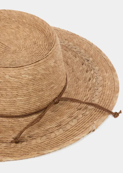A natural straw palm leaf beach hat with a wide brim and brown cord tie for stylish sun protection