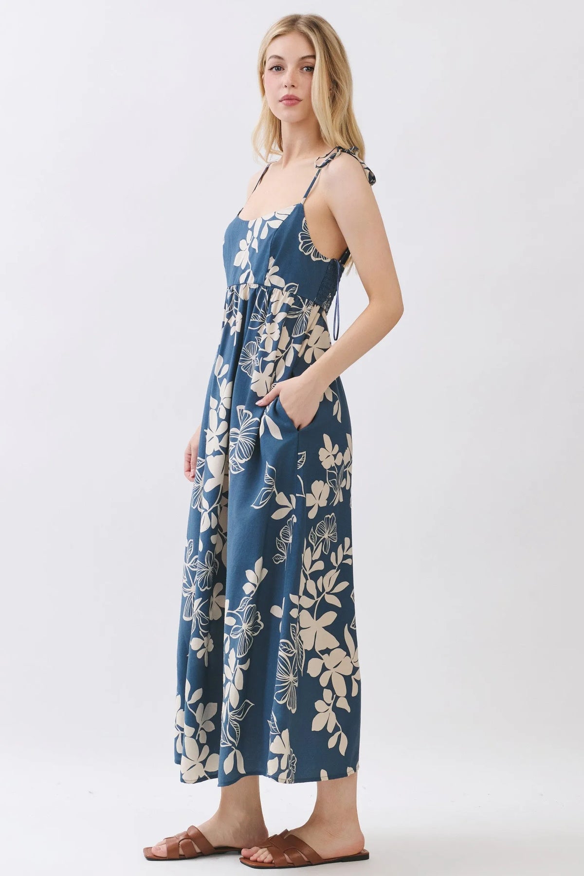 Navy blue floral cami midi dress with cream blossoms featuring thin straps and a tie-side waist detail