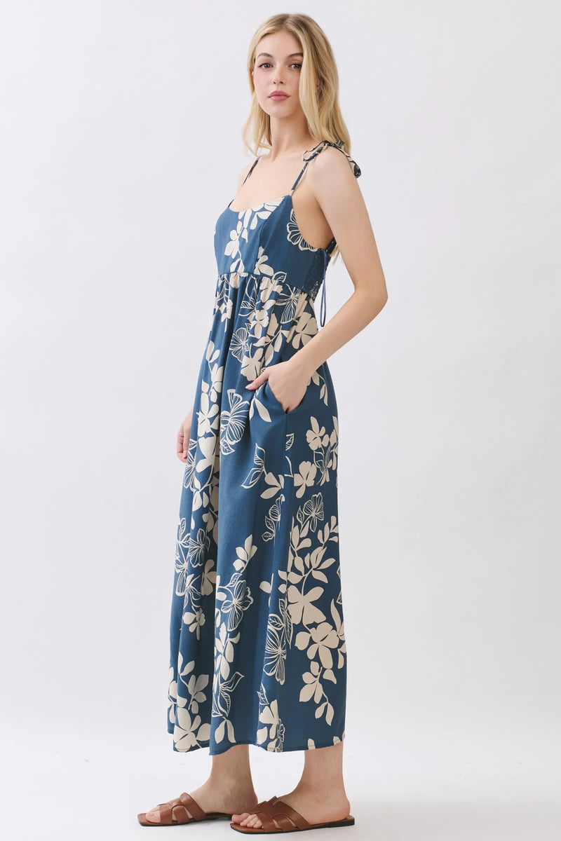 Navy blue floral cami midi dress with cream blossoms featuring thin straps and a tie-side waist detail