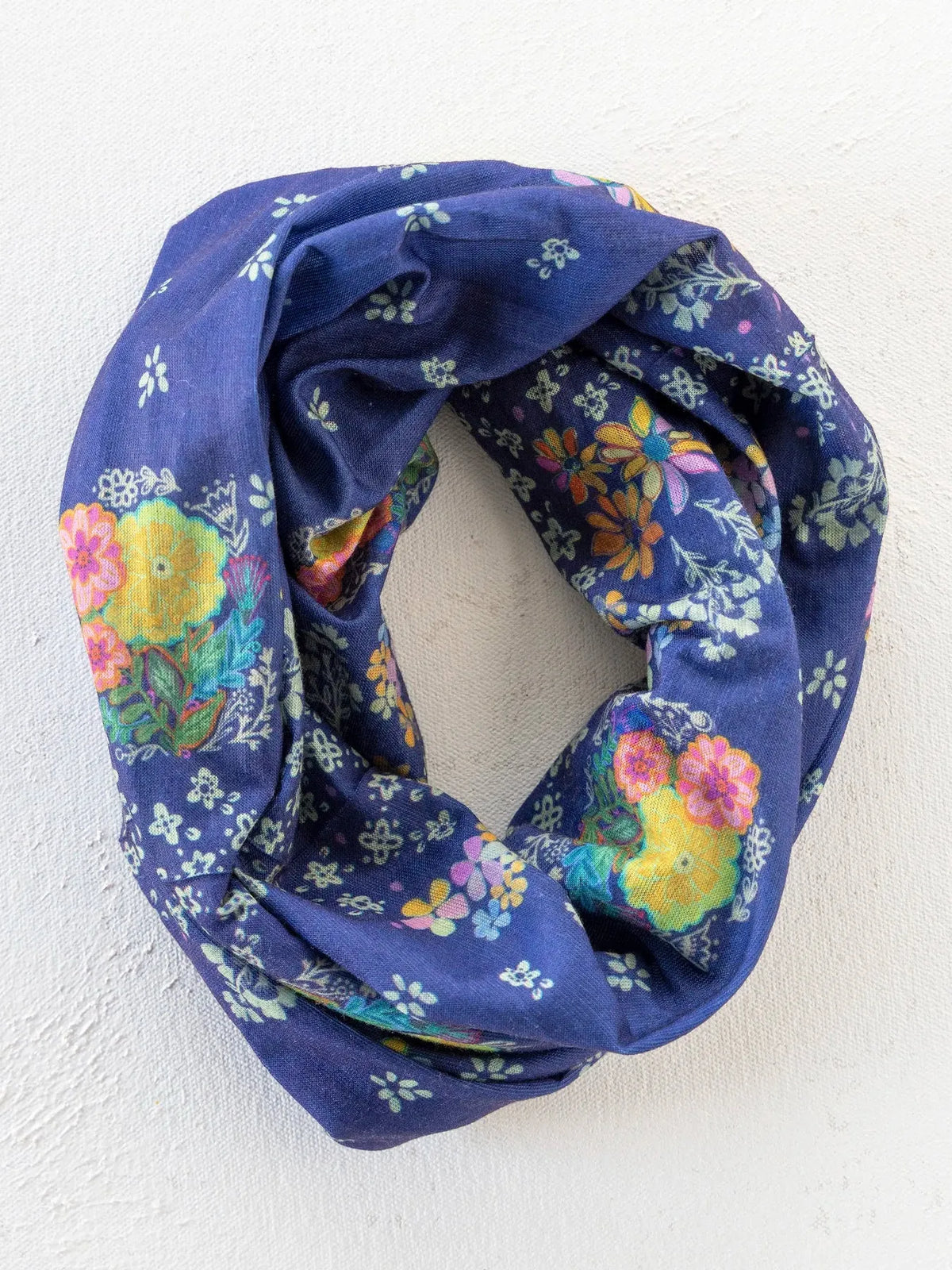 A navy blue boho bandeau scarf with vibrant yellow pink and orange blossoms and small white flowers tropic bandana navy