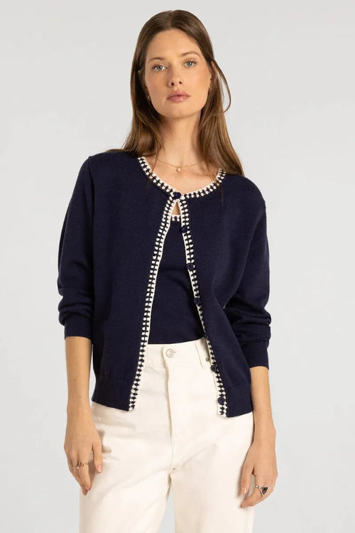 Navy blue knit pippa cardigan with white and black beaded trim along the neckline and front placket by thread & supply