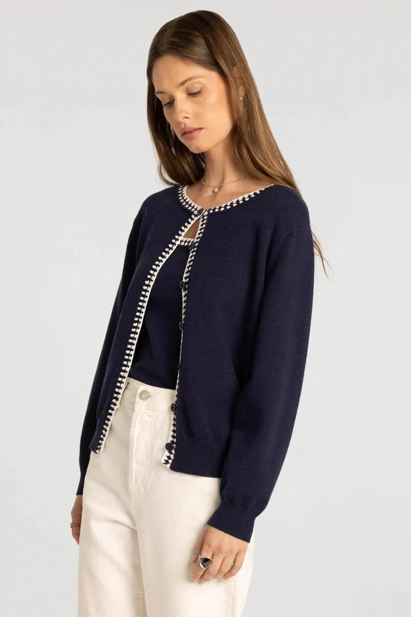 Navy blue knit pippa cardigan from supply pippa with white pearl trim along front opening and side seams