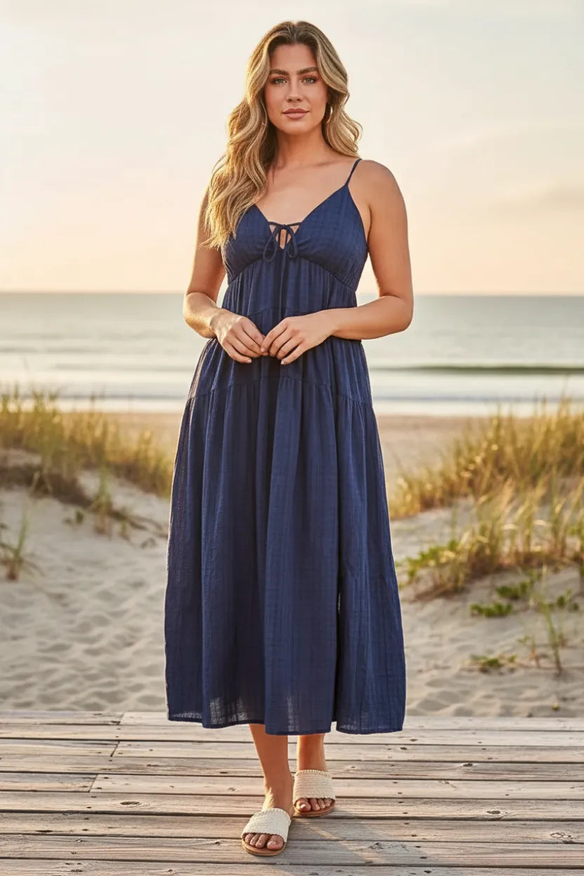 A navy blue flowing maxi dress with thin straps and a tie-front neckline in a tie maxi style without plaid print