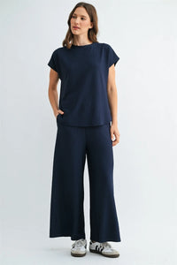 Navy blue textured knit dolman top with short sleeves round neckline and side pockets in ribbed fabric