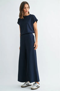 A navy blue textured knit elastic waist two-piece set with a short-sleeved top and wide-leg trousers