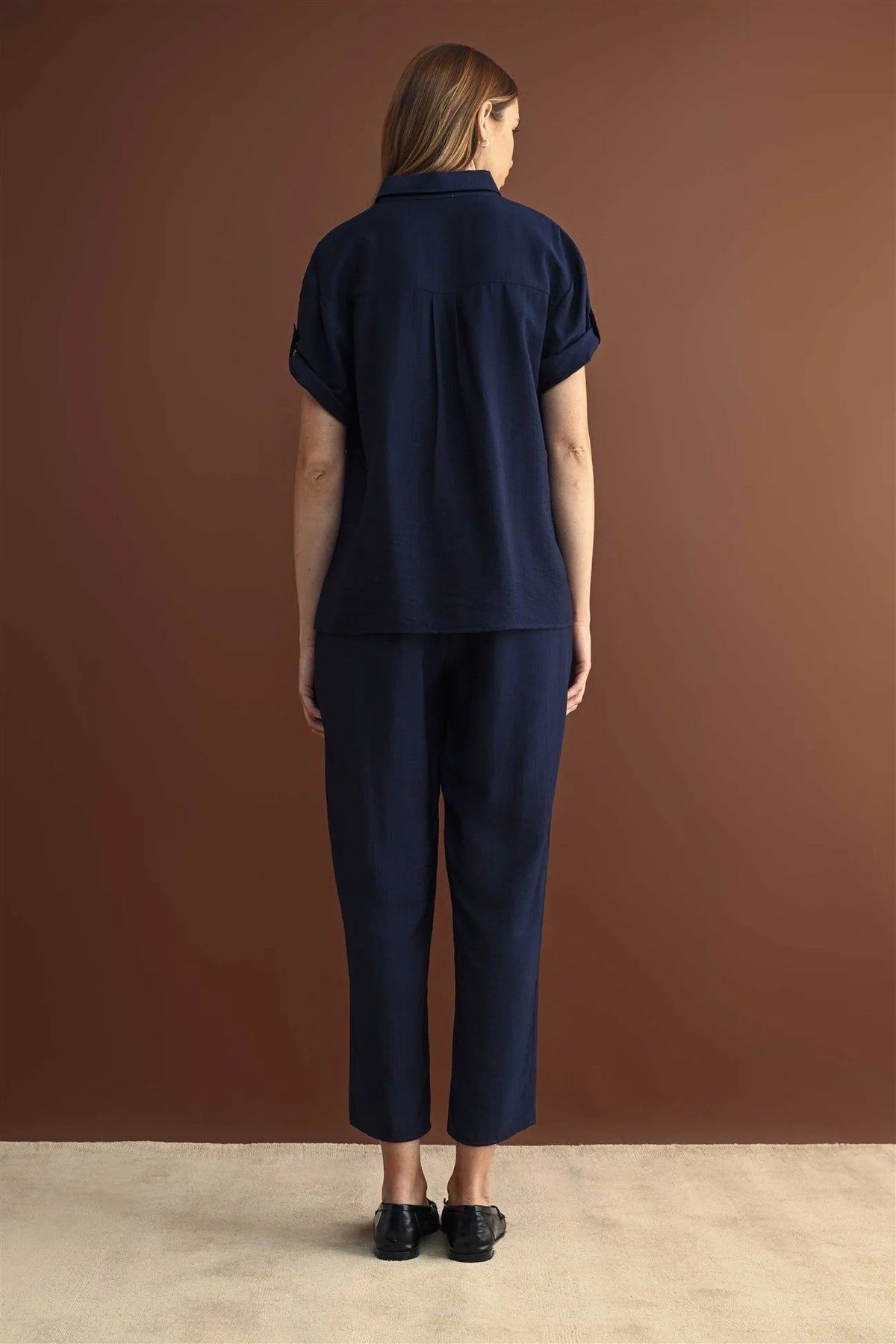 Navy blue short sleeve button down shirt with rolled cuffs paired with matching cropped trousers in cotton fabric