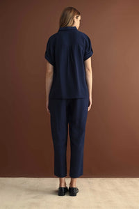 Navy blue short sleeve button down shirt with rolled cuffs paired with matching cropped trousers in cotton fabric