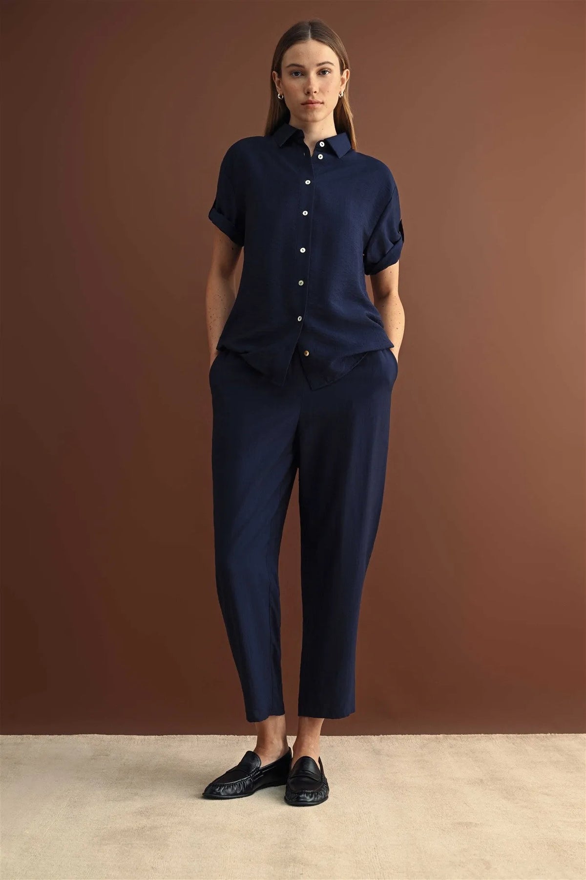 Navy blue short sleeve button down shirt with rolled cuffs paired with matching trousers in breathable fabric