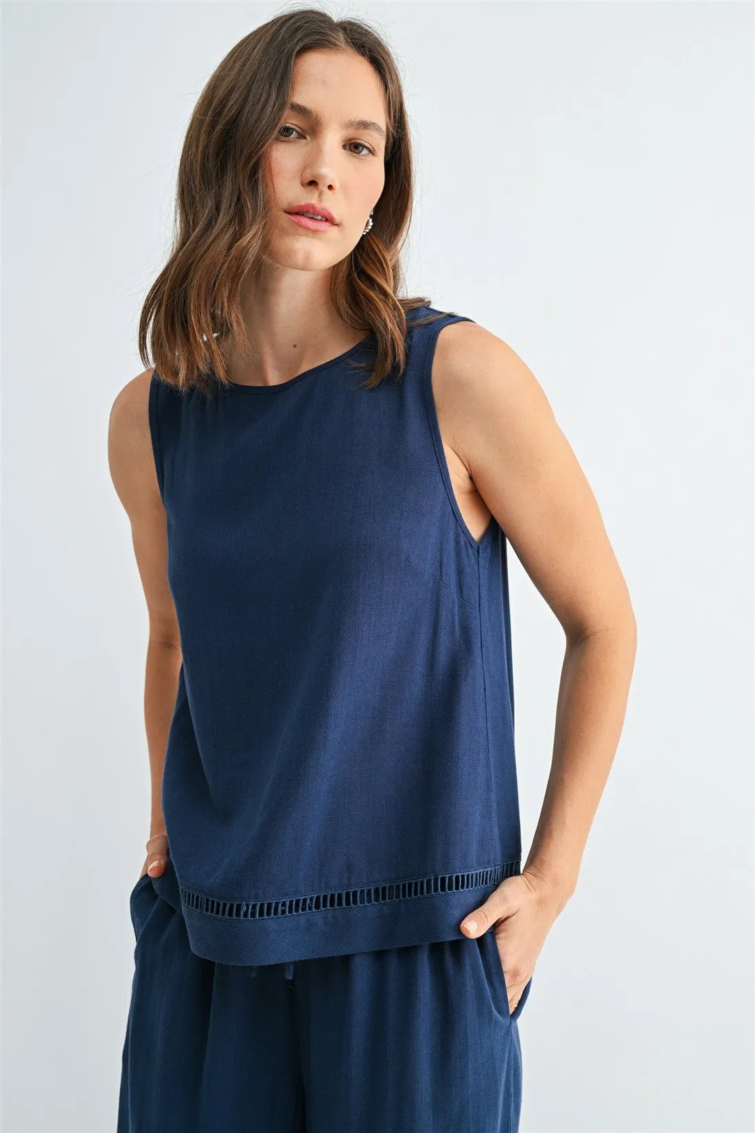 Navy blue sleeveless round neck trim tank with subtle textured fabric and decorative cut-out detailing along the hem