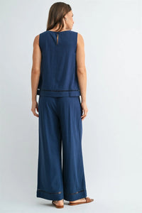 Navy blue sleeveless round neck trim tank with subtle back keyhole and delicate lace trim along the hemline
