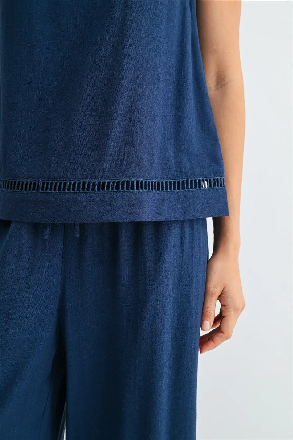 Navy blue sleeveless round neck trim tank with delicate eyelet trim along the hem for elegant casual wear