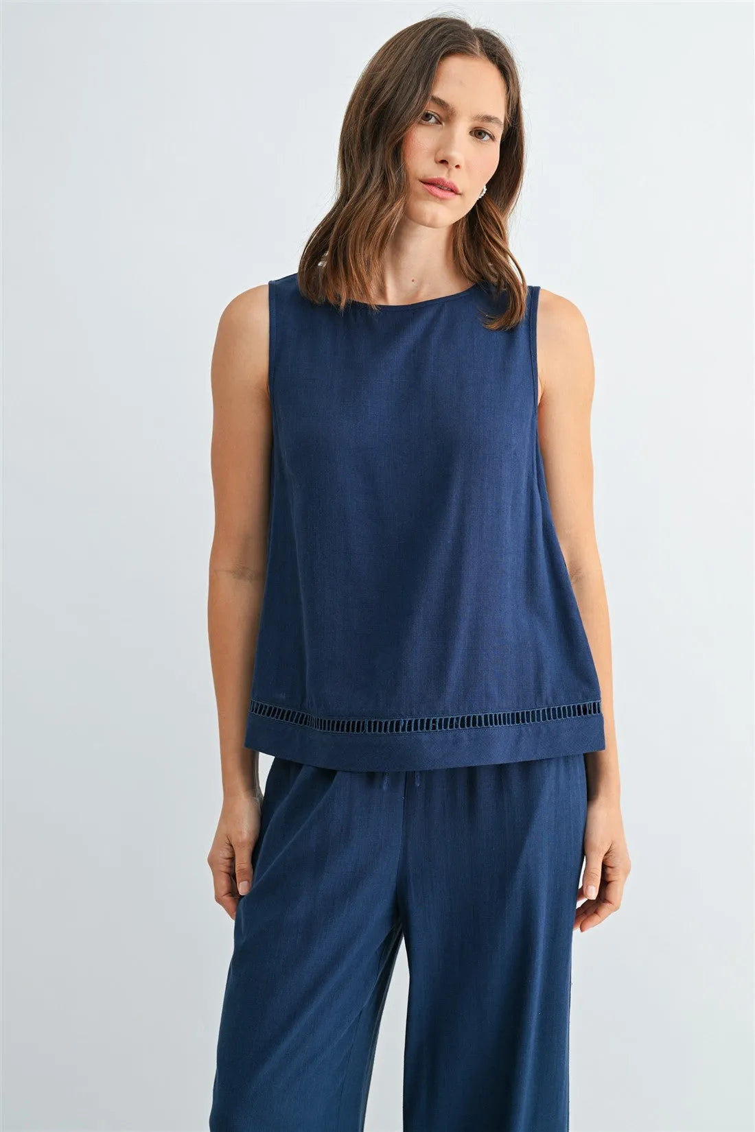 A navy blue round neck trim tank top with a subtle textured hemline featuring a sleeveless design