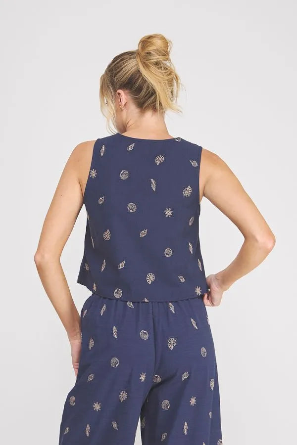 Navy blue sleeveless top with subtle white botanical print featuring seashell lace embroidered woven design