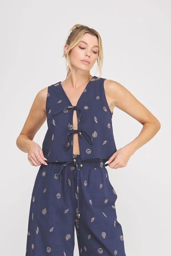 Navy blue sleeveless top with white celestial seashell lace embroidered woven fabric and front tie detail