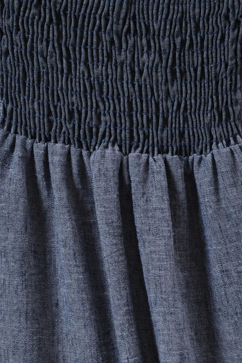 Navy blue sweet heart neck spaghetti strap midi dress with smocked waistband and flowing slightly wrinkled skirt fabric