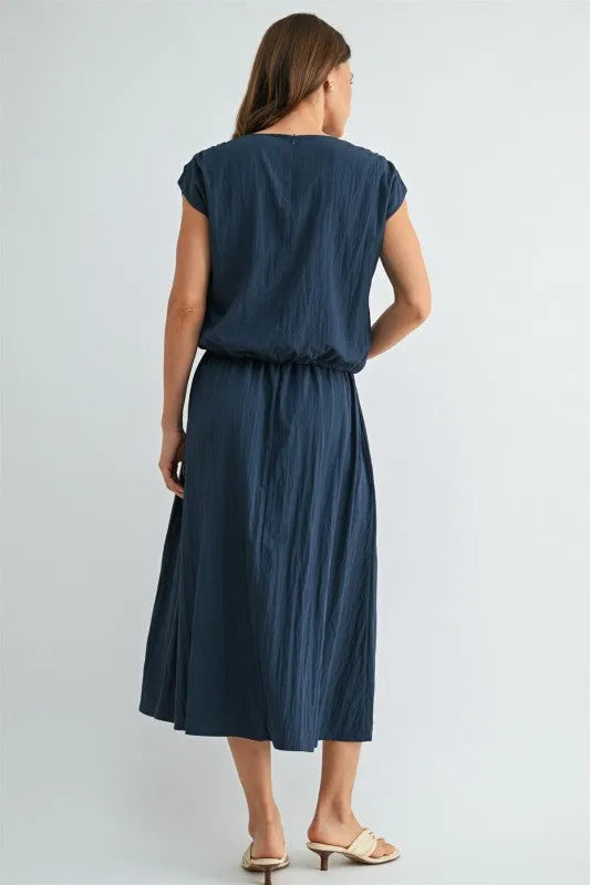 Navy blue softly pleated midi dress with relaxed fit and short sleeves paired with boxy elastic waist blouse