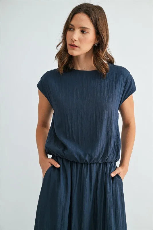 A navy blue boxy elastic waist blouse with short sleeves and a softly draped relaxed fit fabric