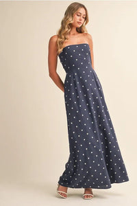 A navy blue strapless polka dot tube maxi dress with a tie back detail perfect for elegant occasions