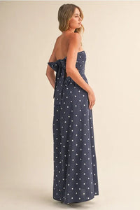 Navy blue polka dot tube maxi dress with strapless design and back tie detail shown from the back side