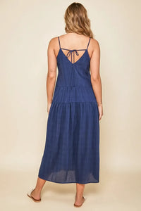 Navy blue tiered tie maxi dress with thin spaghetti straps and back tie detail showcasing the back side