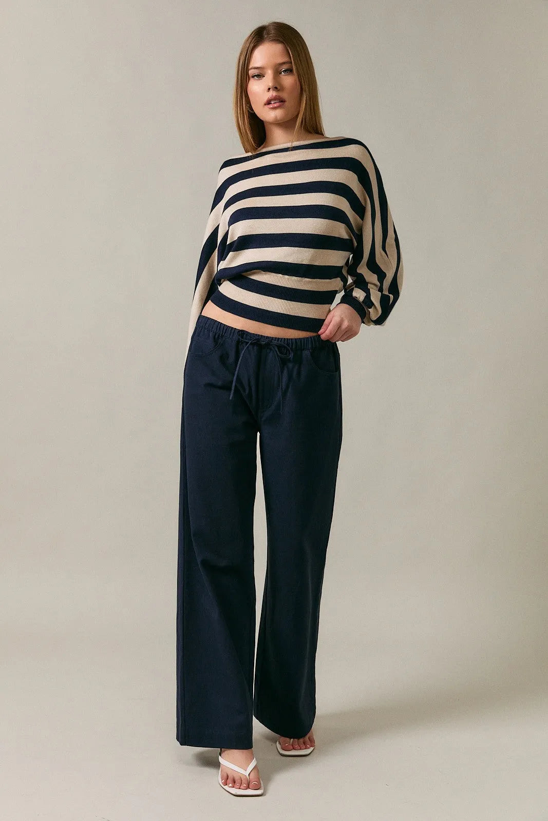 Navy blue wide-leg trousers with drawstring waistband paired with boat neck dolman sleeve sweater top