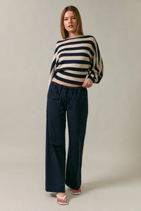 Navy blue wide-leg trousers with drawstring waistband paired with boat neck dolman sleeve sweater top