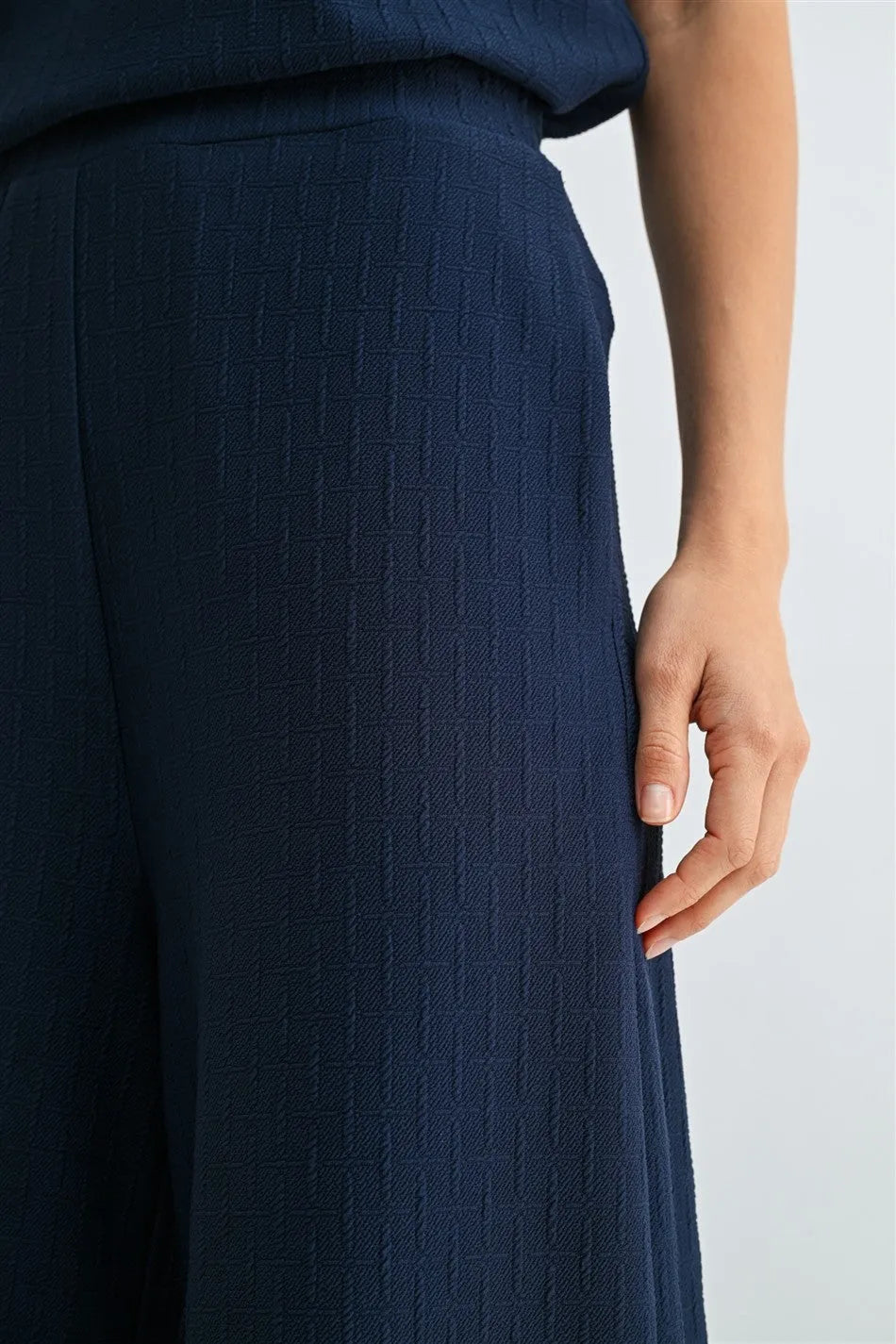 Navy blue wide-leg trousers with textured knit elastic waist and ribbed knit fabric pattern for comfortable wear