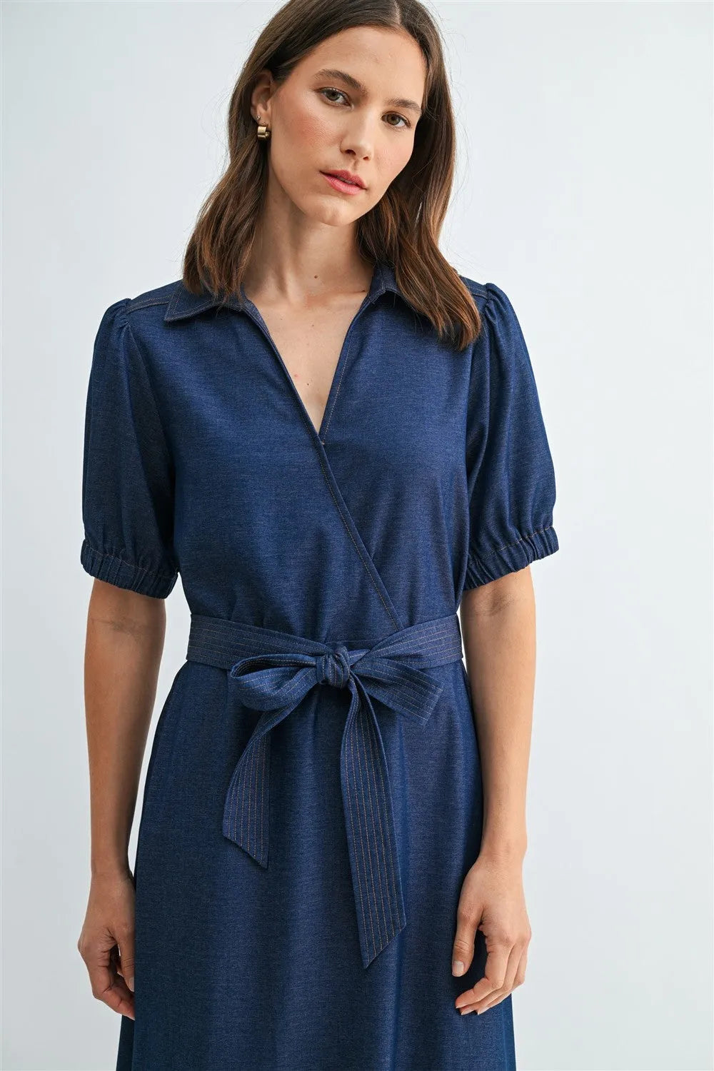A navy blue short sleeve wrap tie waist dress with collar, puffed sleeves, and matching belt at the waist