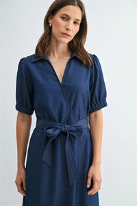 A navy blue short sleeve wrap tie waist dress with collar, puffed sleeves, and matching belt at the waist