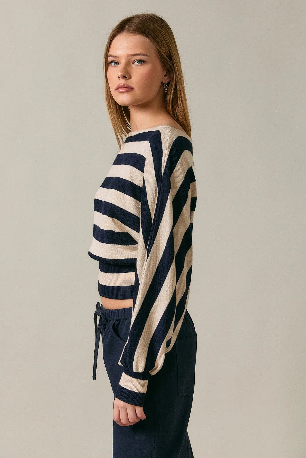 A navy and cream striped boat neck dolman sleeve cropped sweater top with long sleeves in knit fabric