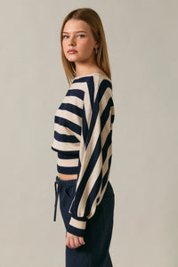 A navy and cream striped boat neck dolman sleeve cropped sweater top with long sleeves in knit fabric