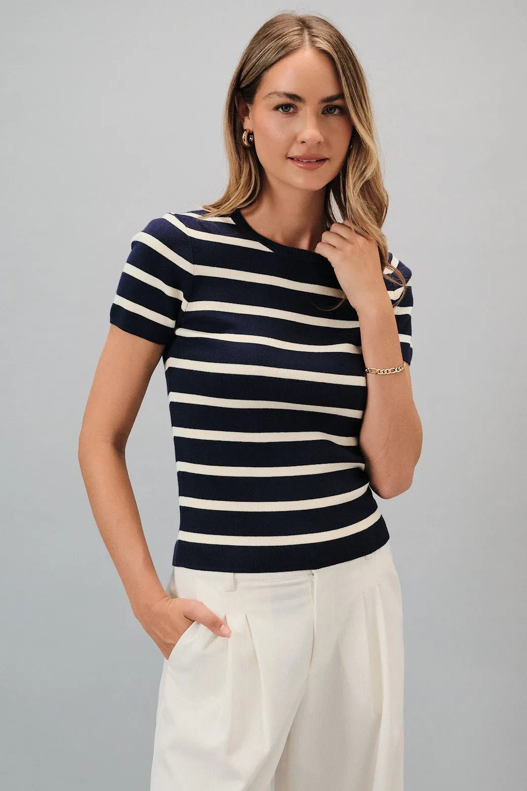 A navy and white horizontally striped knit top with round neck short sleeves and a rounded neckline