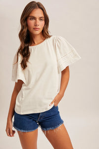 Off-white wing sleeve blouse with puffed sleeves and delicate eyelet detailing along the cuffs