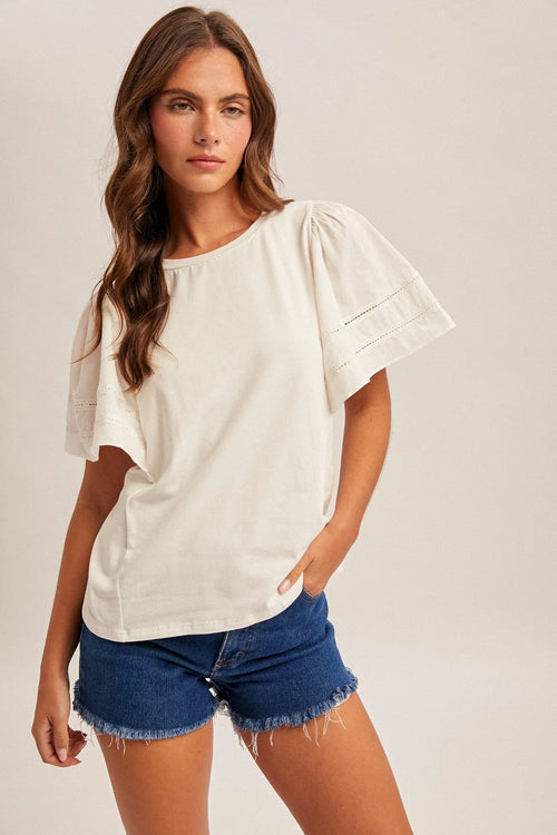 Off-white wing sleeve blouse with puffed sleeves and delicate eyelet detailing along the cuffs
