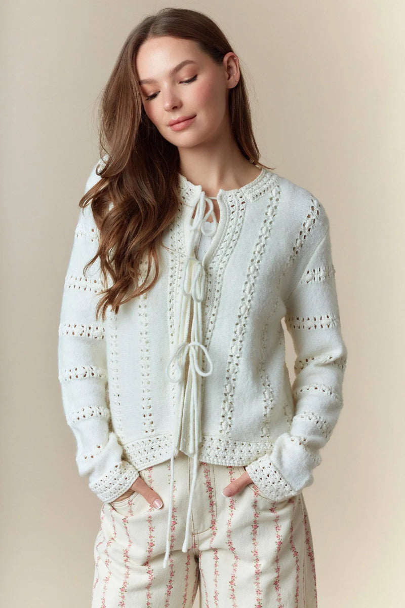 Off-white knit cardigan with hole stripe bows front tie detail and intricate lace-like embroidery design