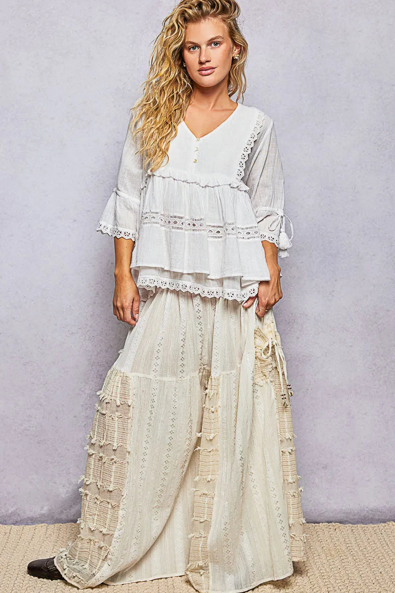 A flowing off-white layered boho v neck half sleeve blouse with relaxed fit and delicate lace trim bell sleeves