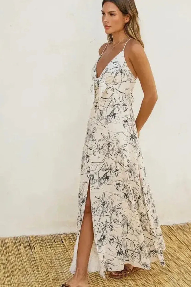 Off-white maxi dress with black tropical palm tree print, thin straps, high side slit ocean vibes knot front maxi dress