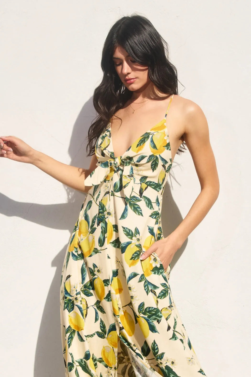 A flowing off-white maxi dress with a vibrant yellow lemon and green leaf pattern vintage lemonade knot front design