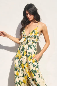 A flowing off-white maxi dress with a vibrant yellow lemon and green leaf pattern vintage lemonade knot front design