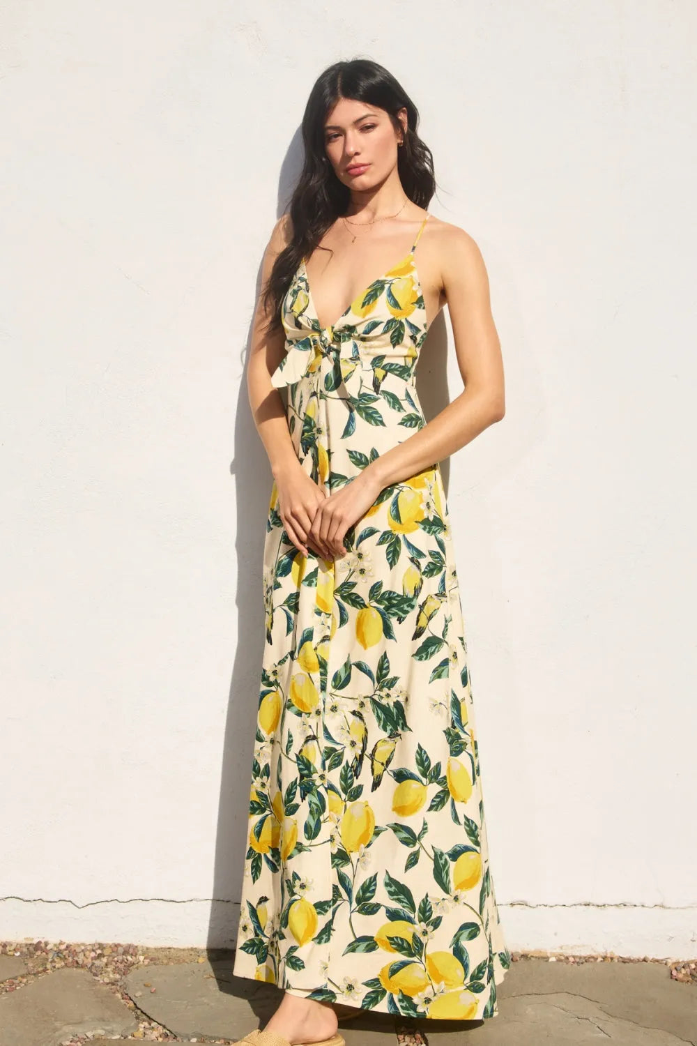 A flowing off-white maxi dress featuring a vintage lemonade knot front with vibrant yellow lemon and green leaf pattern
