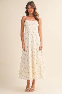 A flowing off-white floral twill paneled midi dress with delicate spaghetti straps and a subtle floral pattern