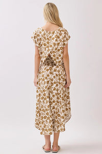 A flowing off-white midi skirt with a delicate brown floral pattern featuring a smocked waistband and flutter sleeves