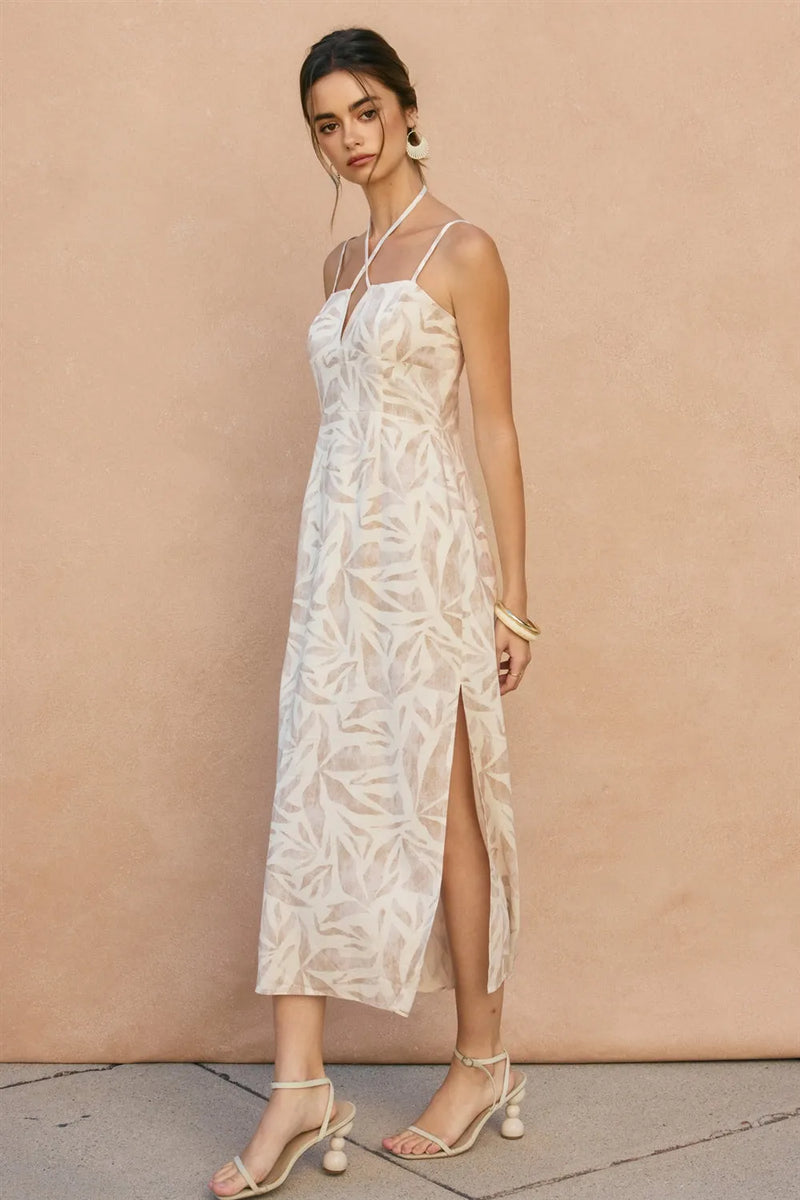 Off-white flowing midi dress with delicate tropical leaf pattern and thin spaghetti straps leaf v cut sleeveless maxi dress