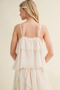 Off-white delicate lace inset tiered camisole with flowing fabric lace trim straps and ruffled hem