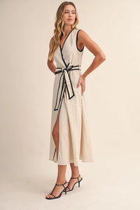 Off-white midi dress with black contrast piping wrap design along neckline waistband and side slit