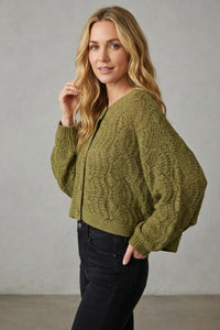 Olive green long sleeve crochet cable knit cropped cardigan showcasing sleeve crochet details in knit fabric