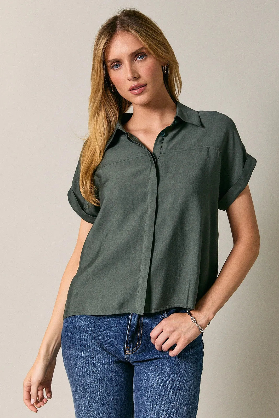 Olive green short-sleeved collard wide shoulder button down shirt with rolled cuffs and subtle sheen