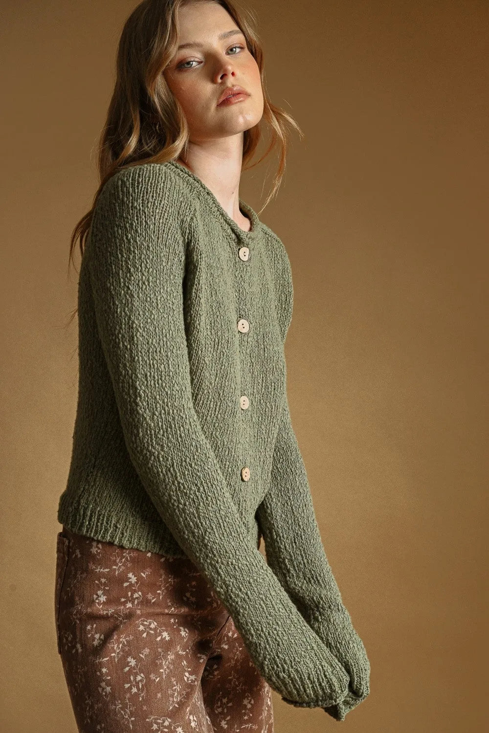 Olive green sweater knit cardigan with cream-colored buttons featuring textured knit fabric and button front closure