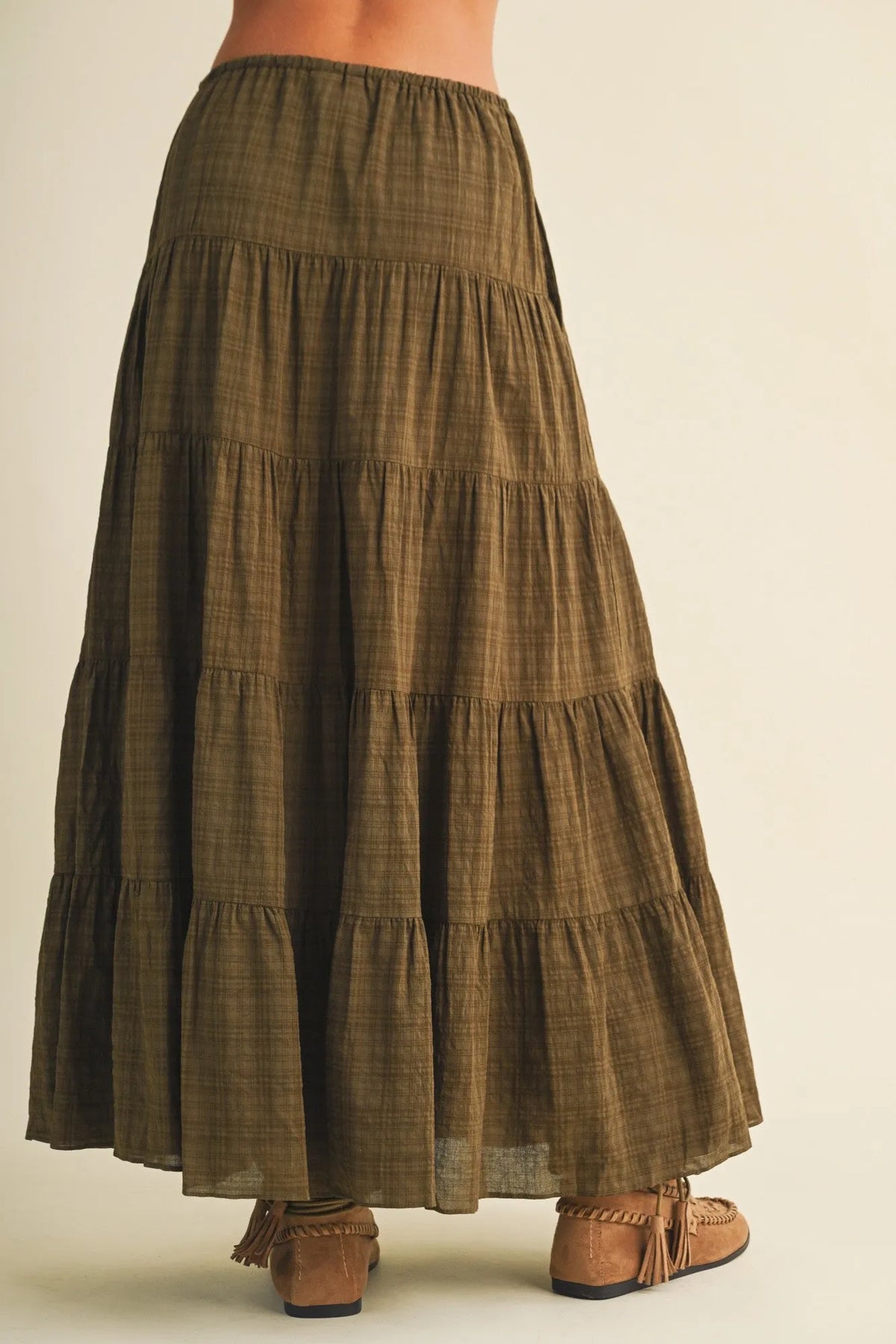 Olive green geometric woven tiered maxi skirt with subtle plaid pattern and elastic waistband in woven tiered maxi style